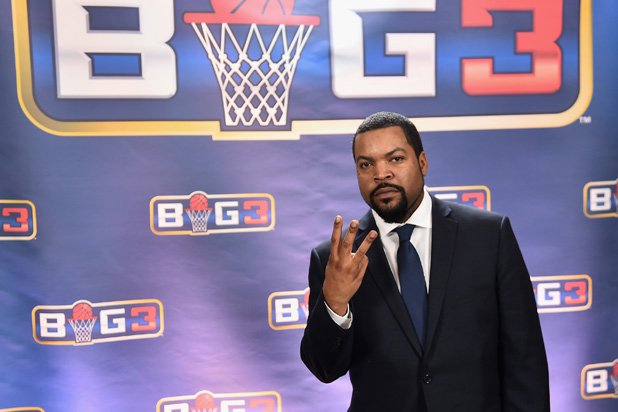 Big3 Founder, Ice Cube, posing with Big3 logo in background.